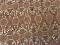 Decorative fabric with floral patterns and rhinestones on a brown background