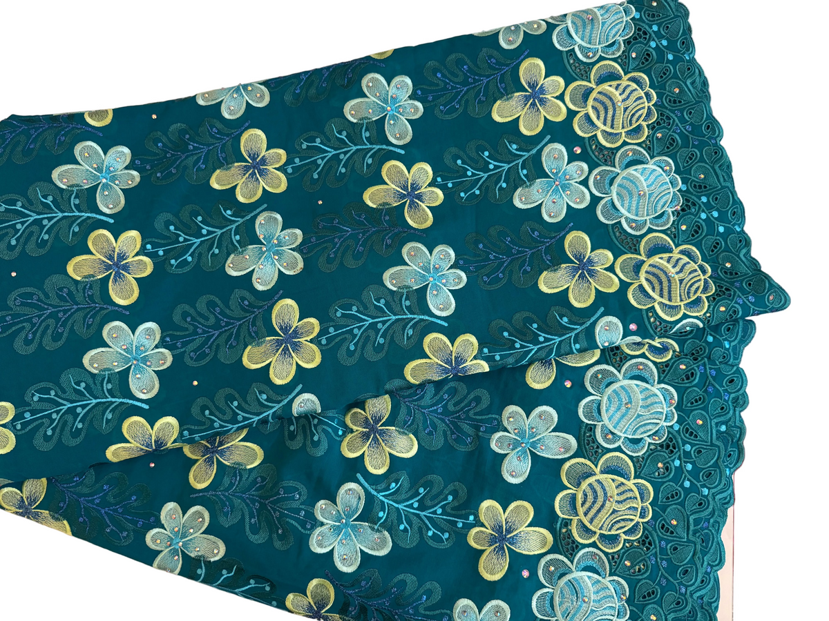 Floral patterned fabric with blue and yellow flowers on a teal background.