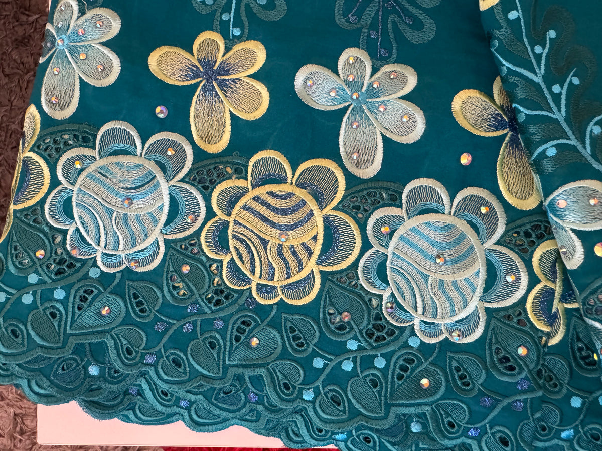Embroidered fabric with floral patterns on a teal background
