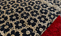 Close-up of black floral patterned fabric with a red textured fabric underneath