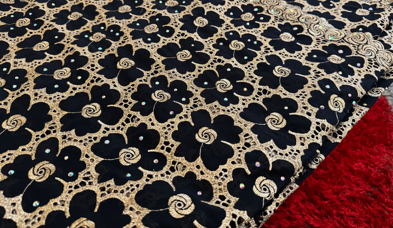 Close-up of black floral patterned fabric with a red textured fabric underneath