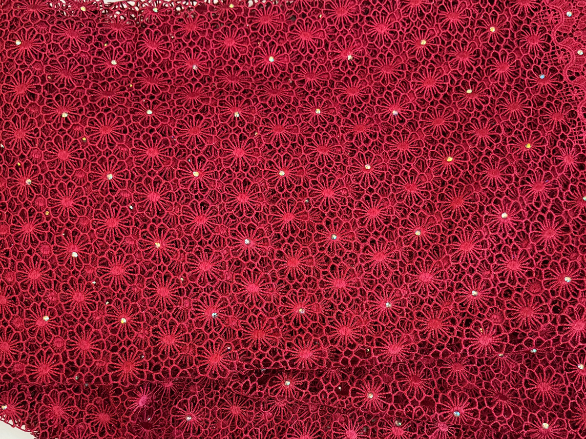 Red lace fabric with a pattern on a white background