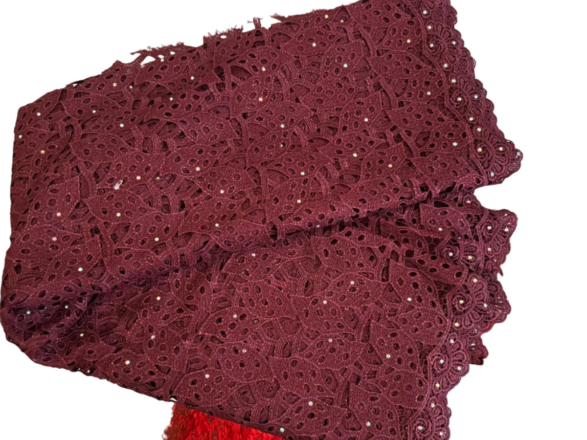 Maroon lace fabric on a textured surface